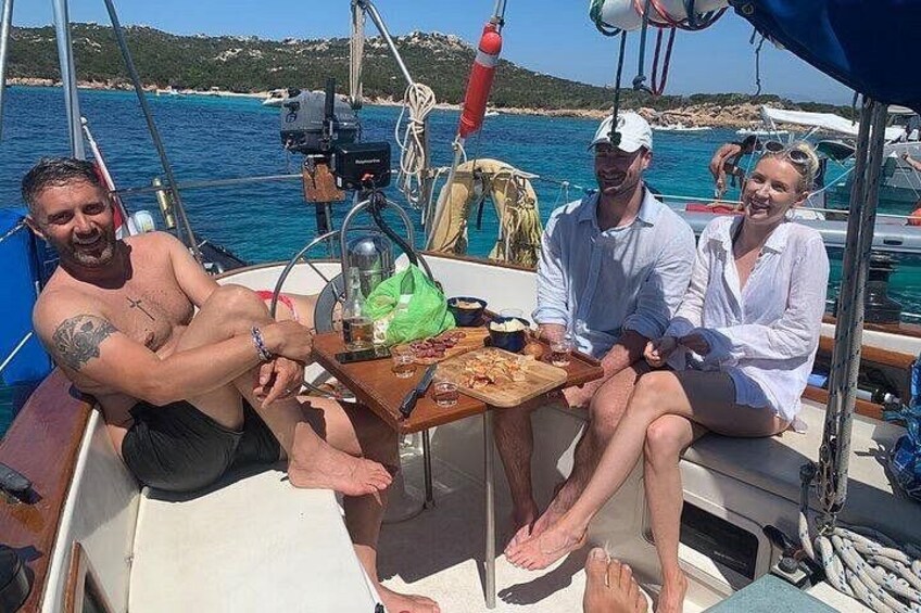 Un grupo de personas en un bote, con una mesa al frente. 5