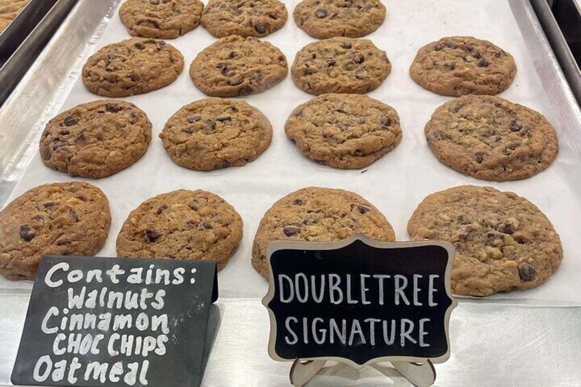 Cookies with a sign indicating they contain walnuts, cinnamon, chocolate chips, and oatmeal. 3