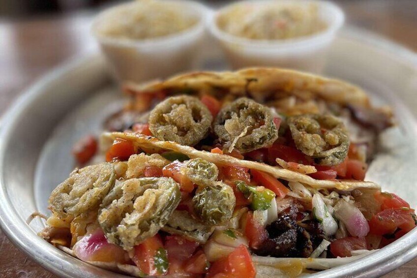 A plate of tacos with a side of salsa and a small bowl of sauce. 2