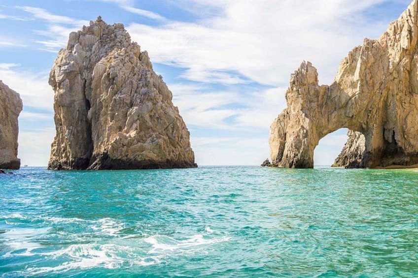 A coastal landscape with rock formations and clear turquoise water. 2