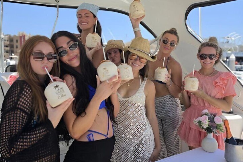 Un grupo de personas en un bote sosteniendo bebidas de coco. 4