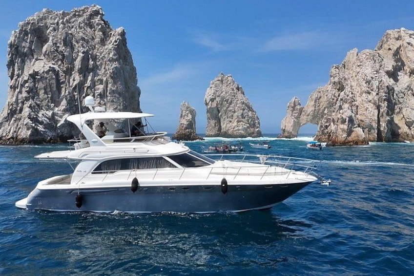 A yacht on calm waters with rocky formations in the background. 4