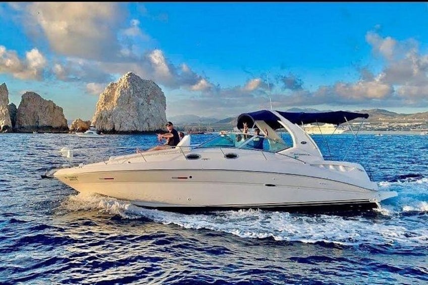 A white motorboat on water with a rocky coastline in the background. 5