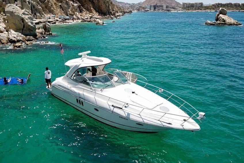 Un yate blanco amarrado a la costa rocosa, con agua turquesa cristalina. 3