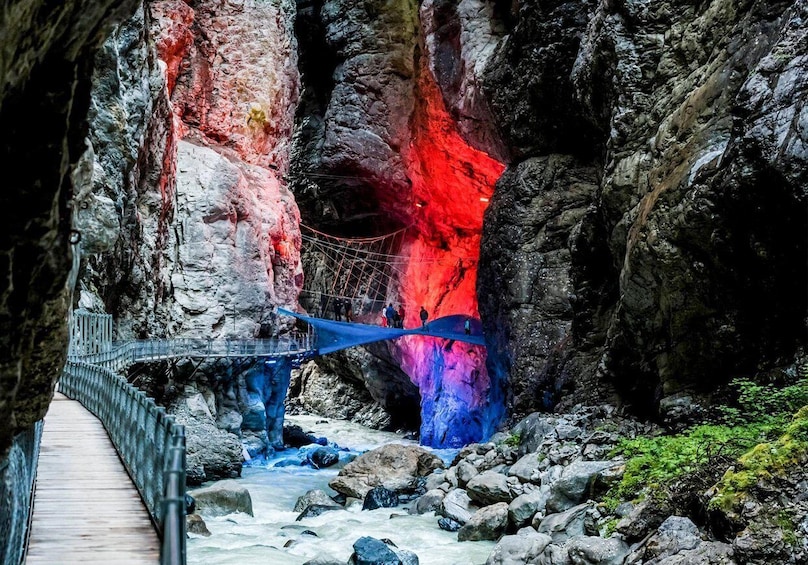 A wooden bridge over a river in a rocky gorge with colorful rock formations. 3