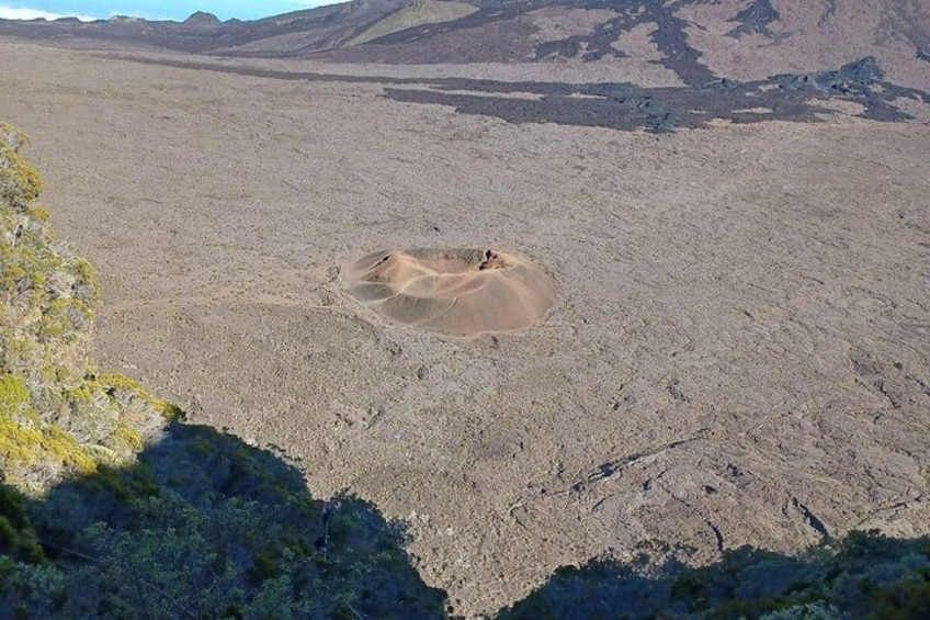 A barren landscape with a large sand dune and rocky terrain. 3