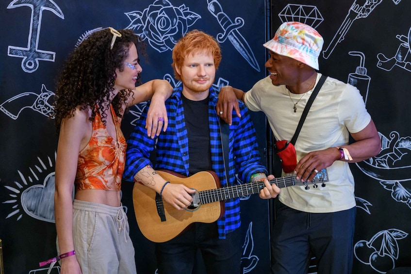 Three people, one playing an acoustic guitar. 5