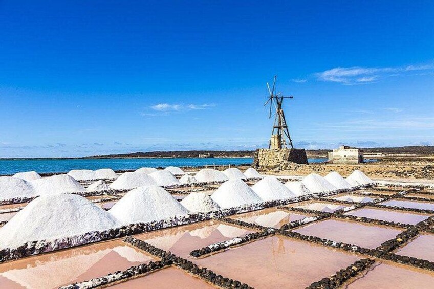 A windmill, salt pans, and a coastal landscape. 2