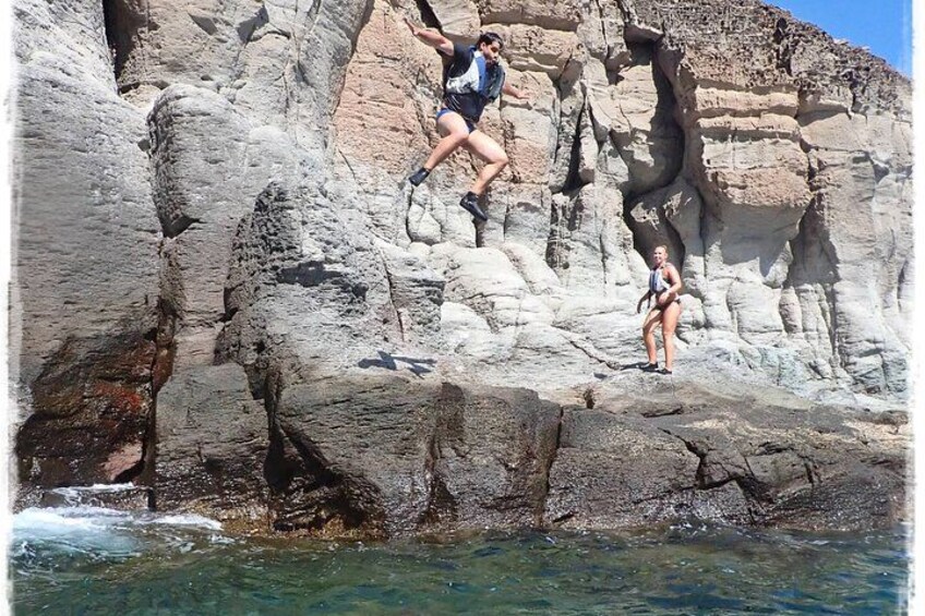Eine Person klettert an einer felsigen Klippe am Meer. 2