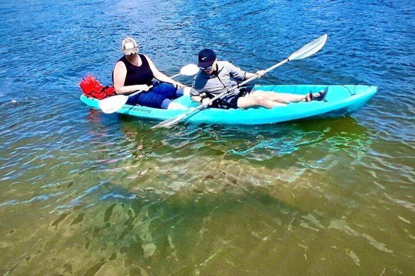 Two people kayaking on a calm body of water. 4