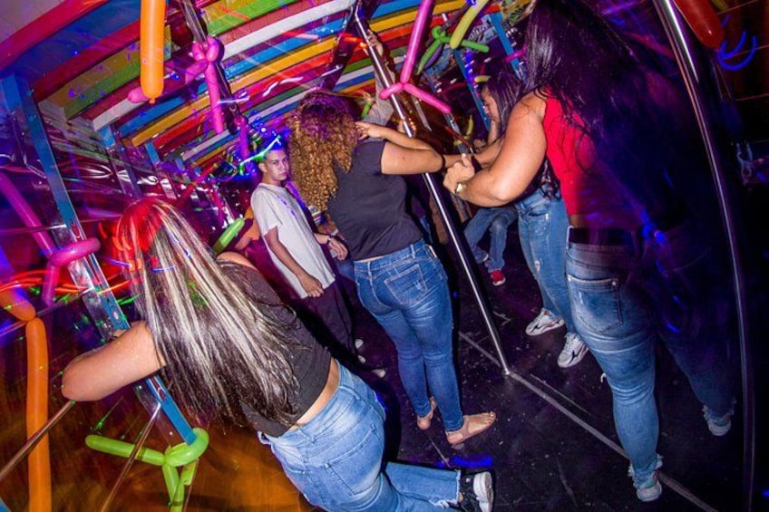 People in a room with colorful decorations and balloons. 5