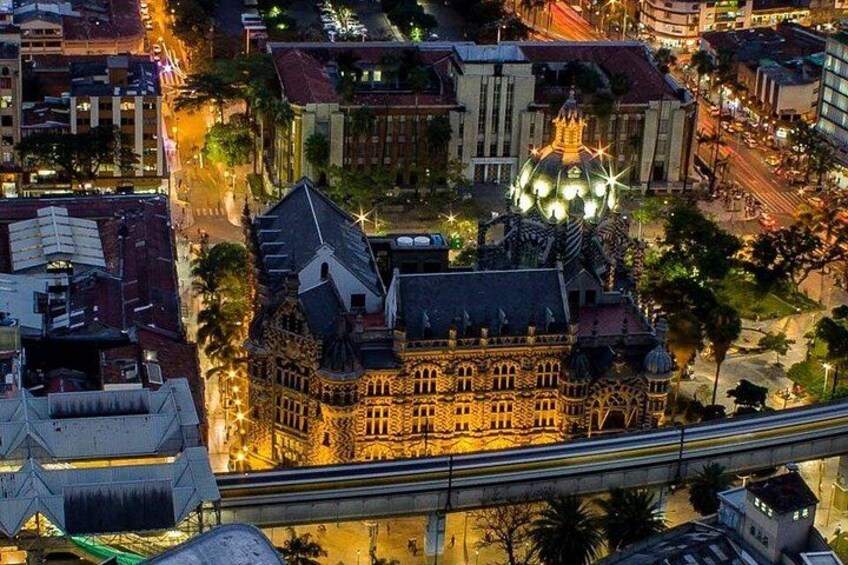 A cityscape at dusk with a prominent building featuring a dome and a large, illuminated structure. 3