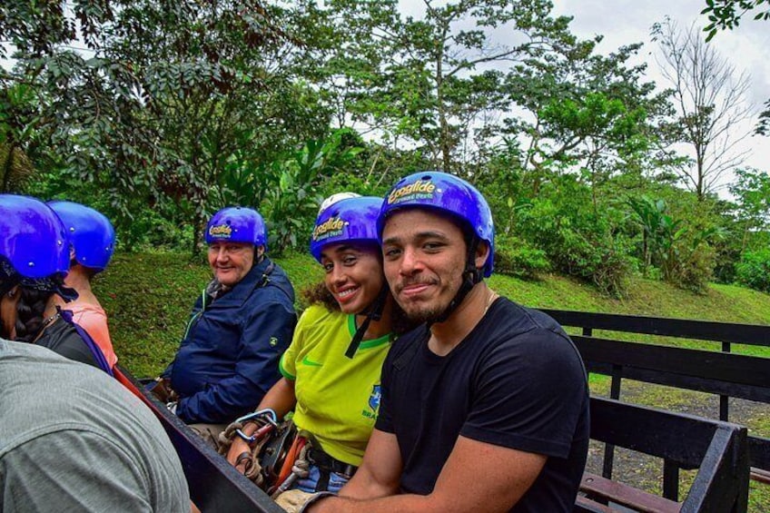 Des personnes portant des casques bleus et des vêtements décontractés sont assises sur un banc dans un parc, avec de la verdure en arrière-plan. 2