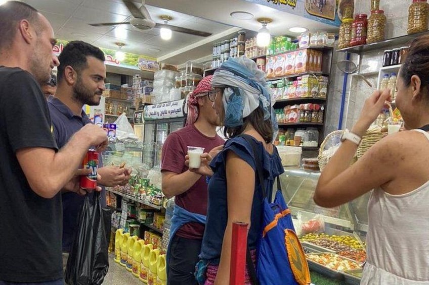 A market with people shopping and a woman in traditional attire. 3