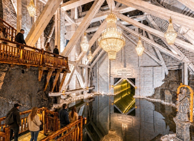 An interior with wooden beams, chandeliers, and a central glass window. 5