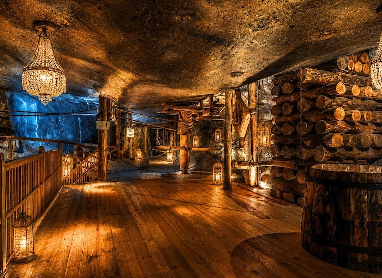 A wooden interior with a chandelier, lanterns, and a log wall. 5