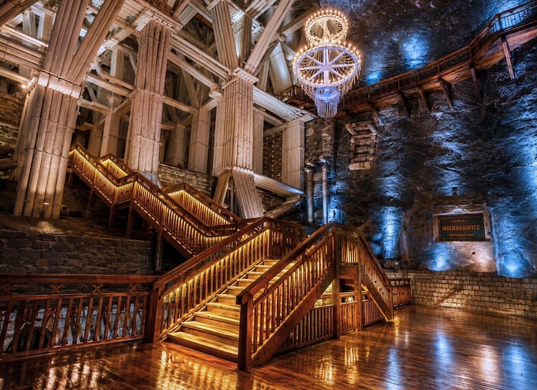 A grand staircase with wooden railings and a chandelier. 2