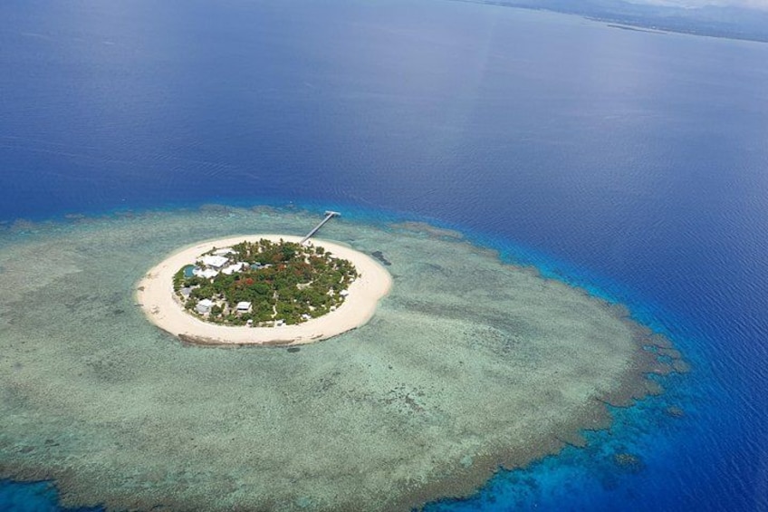An island surrounded by clear blue waters. 5