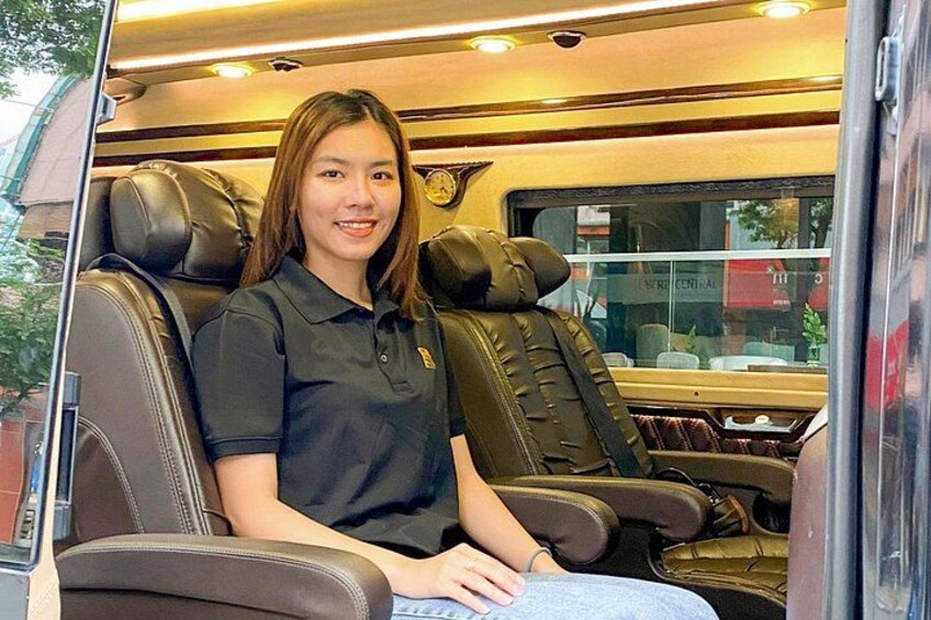 A person seated in a bus interior with leather seats and a window. 1