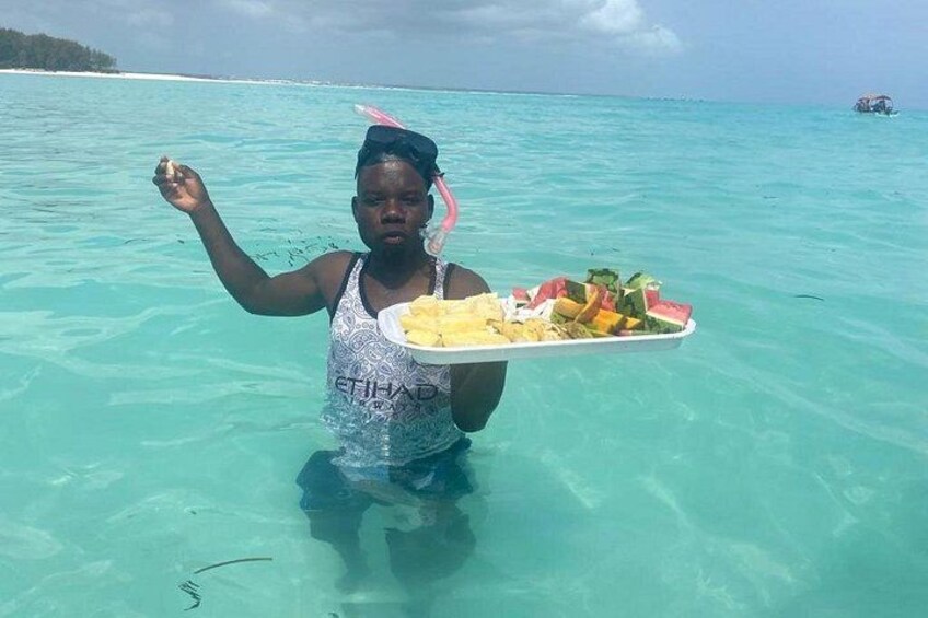 A person holding a tray with food in a clear blue sea. 2