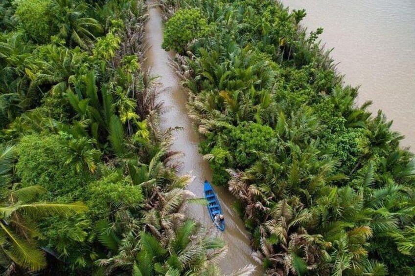 Un estrecho canal rodeado de exuberante vegetación tropical. 5