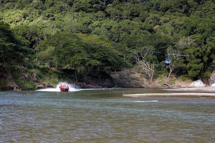 Ein rotes Boot saust durch einen Fluss, der von dichtem Wald gesäumt wird. 5