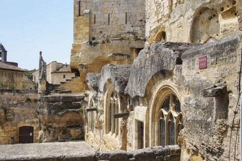 Un edificio histórico de piedra con ventanas de arco y un letrero que indica un museo. 2