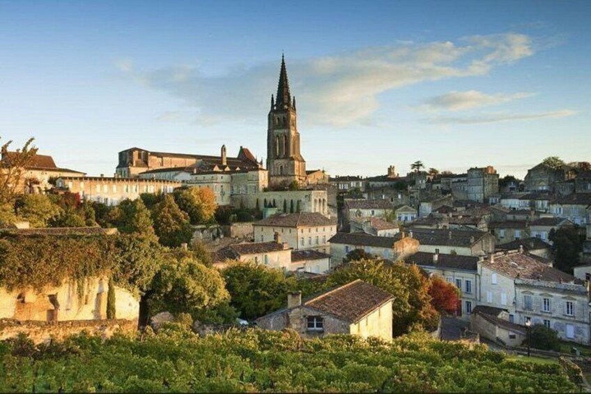 Un pueblo histórico con una imponente torre de iglesia, abundante vegetación y arquitectura tradicional. 3