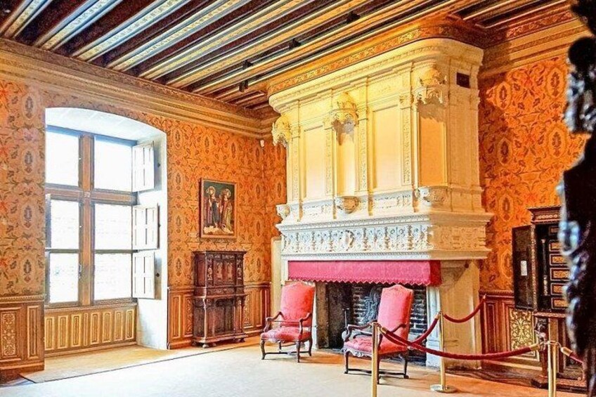 Una habitación con paneles de madera decorativos, una chimenea con cortinas rojas y un ventanal grande. 4