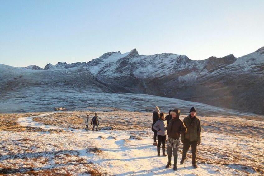 Un groupe de personnes marchant sur un sentier enneigé dans une région montagneuse. 4