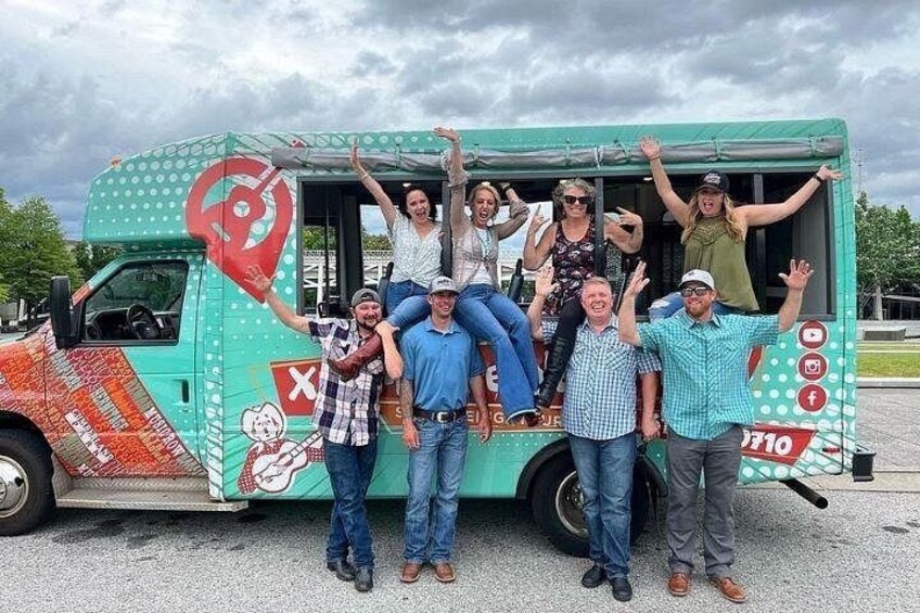 A group of people posing in front of a food truck with a colorful design and a logo. 2