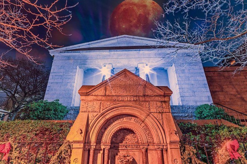 A building with a large archway and a mural above it. 3