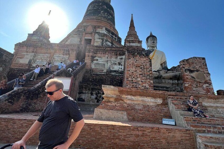 A large Buddha statue, ancient brick ruins, and a person standing in front. 5
