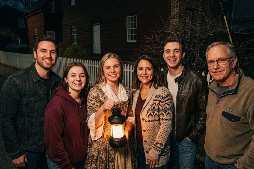 Un grupo de personas al aire libre de noche, sosteniendo un farol. 4