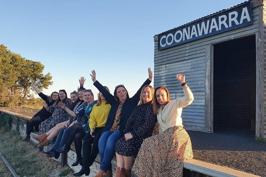A group of people sitting on a bench in front of a building labeled 'COONAWARRA.' 5