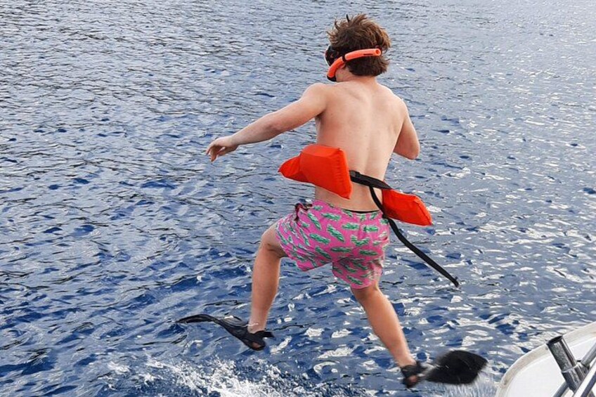 En person i en båd med snorkel og finner, iført en rød redningsvest. 3