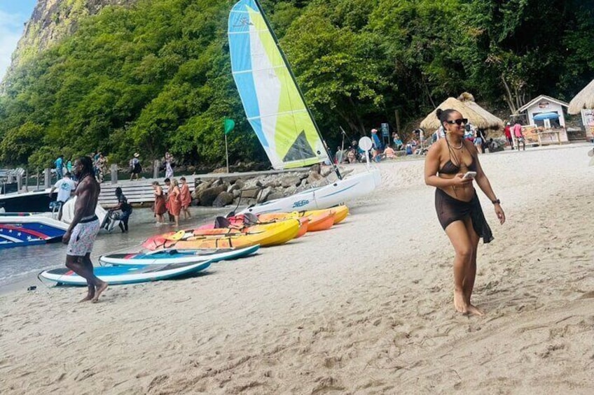 Una playa con gente, un velero y canoas. 2