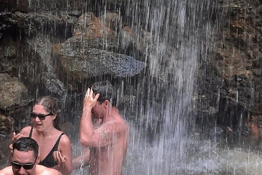 Una cascada con gente disfrutando del agua. 1