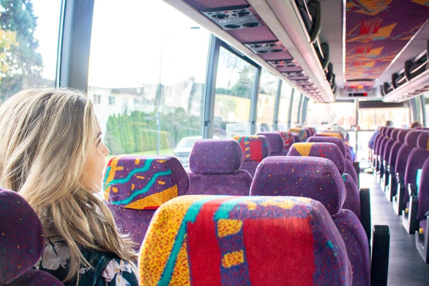 A bus interior with colorful seats and large windows. 2