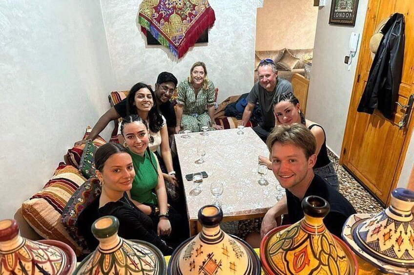 A group of people around a table with ornate vases. 1