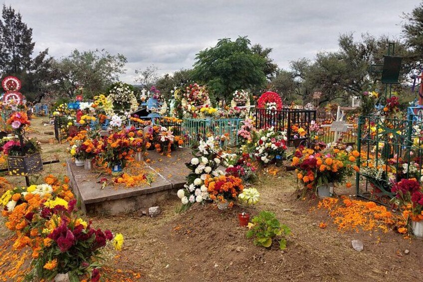 Un cementerio con numerosas lápidas decoradas con flores coloridas. 1