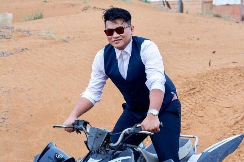 A person riding a quad bike in a desert landscape. 3