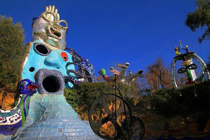 A colorful, surreal sculpture garden with abstract figures and a bicycle. 1