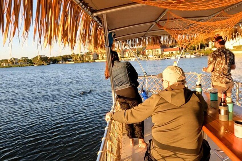Un barco con toldo, una persona manejando y otra de pie en la popa. 2