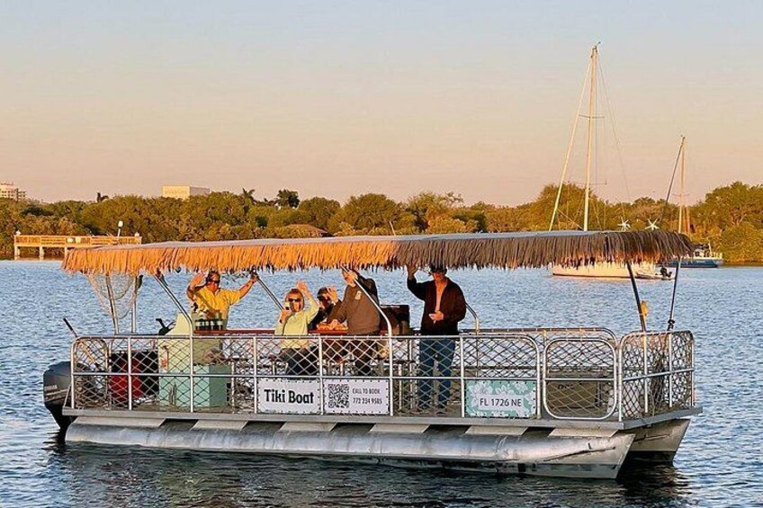 Un bote con pasajeros, un techo de paja y un letrero que dice 'Tiki Boat'. 5