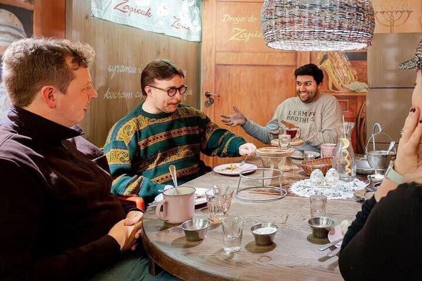 Eine Gruppe von Personen sitzt an einem Holztisch mit verschiedenen Gerichten und Gläsern. 2