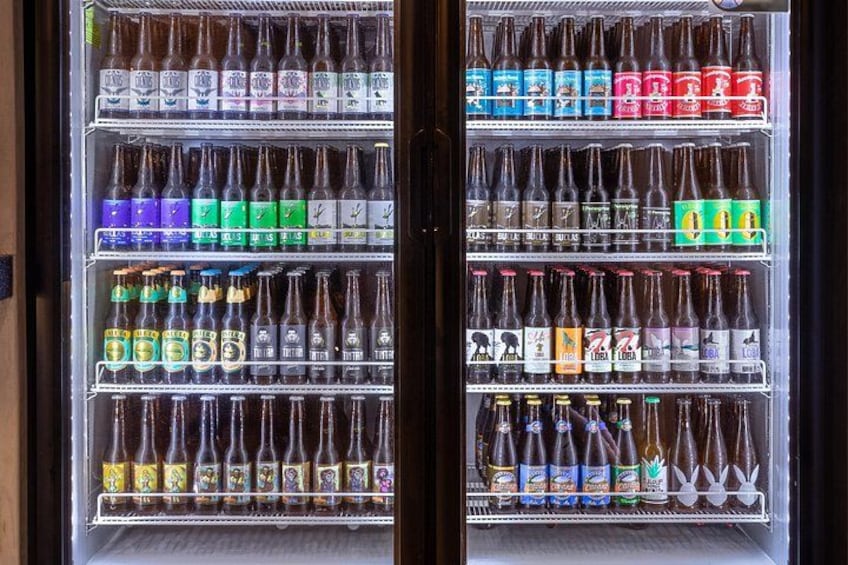 A refrigerated display case with multiple shelves of bottled beverages. 2
