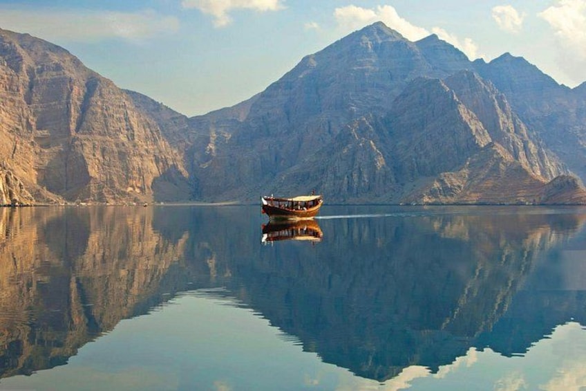 A boat on a calm lake with mountains in the background. 1