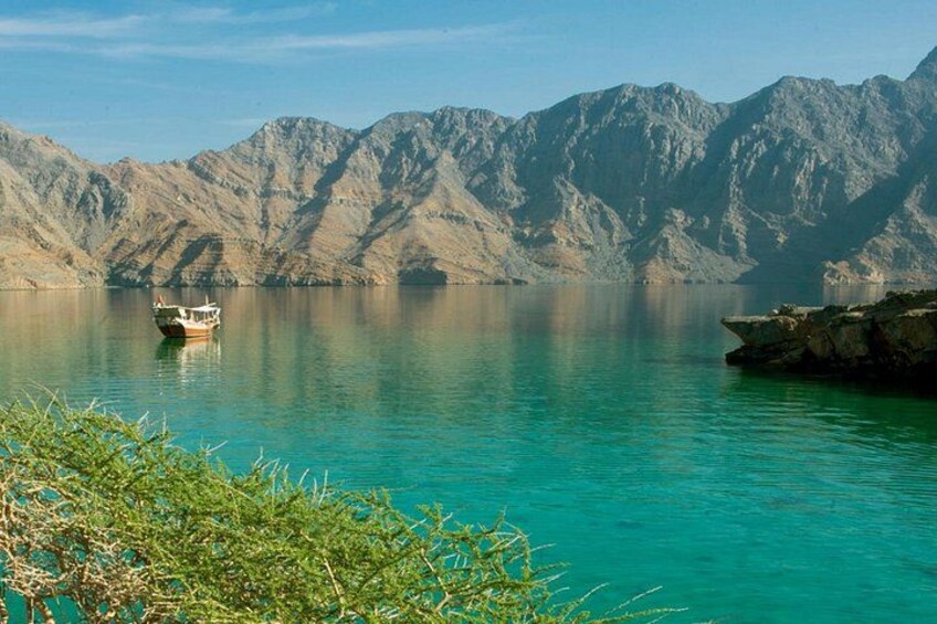 A boat on a turquoise lake with mountains in the background. 5