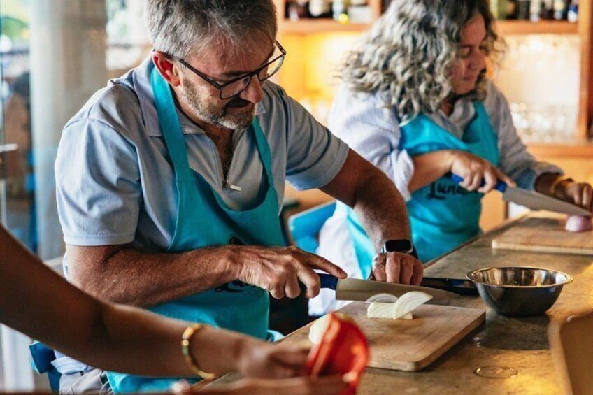 Two people in aprons preparing food at a counter. 4